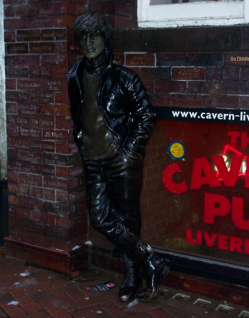 A rather poor statue of John Lennon outside The Cavern Pub. Also, each brick in the wall has the name of a band that has performed at The Cavern Club, Liverpool (2006)