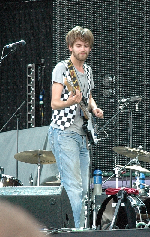 Fyfe Dangerfield wearing his chequered wait-coat and playing guitar. Manchester (2008)
