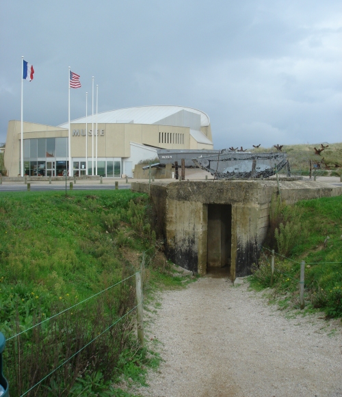 An authentic bunker at Utah beach. An impressive D-Day museum in the background, France (2006)